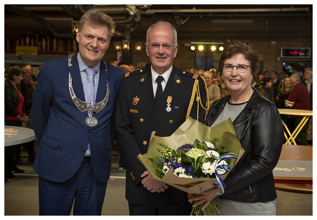 Burgemeester Hamming overhandigt een lintje aan de heer Van der Blom