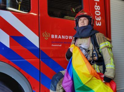 Tom van Lingen in brandweerpak met de pride vlag