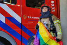 Tom van Lingen in brandweerpak met de pride vlag
