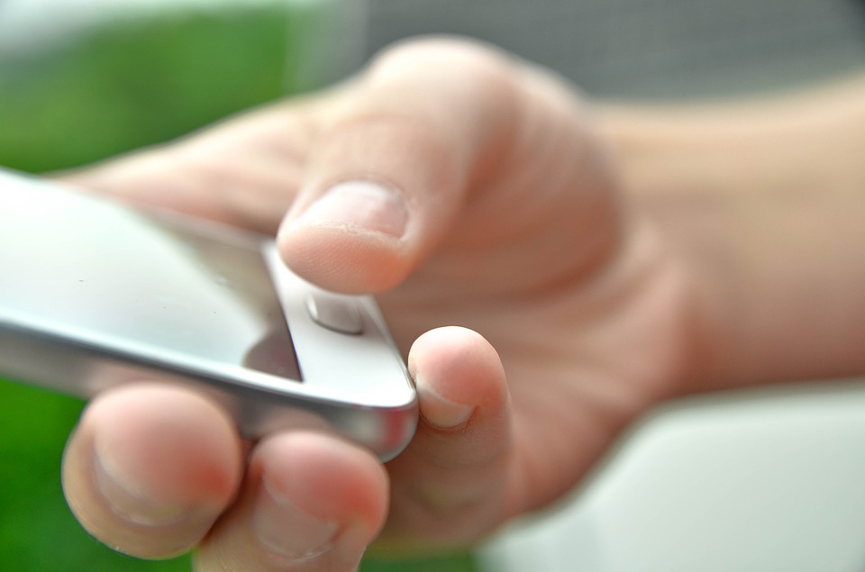 Foto van een hand met daarin een mobiele telefoon